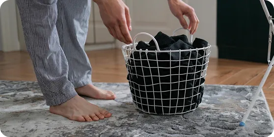 Sorting black Ion Sportswear laundry in a wire basket.